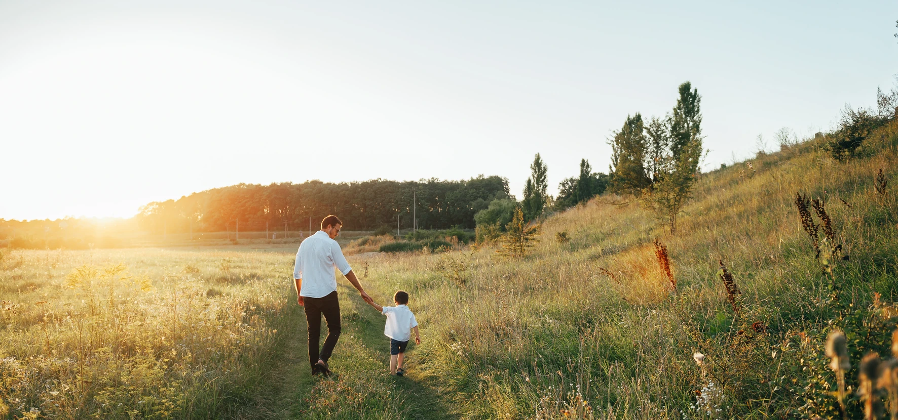 A parent and young child playing together on grass