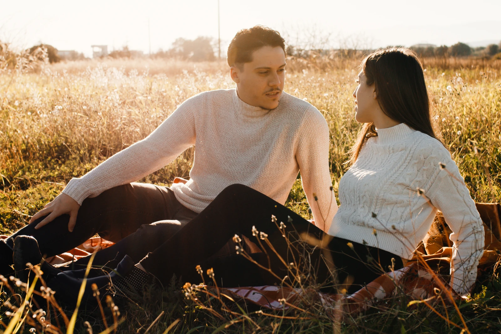 A couple sitting and talking together in long grass